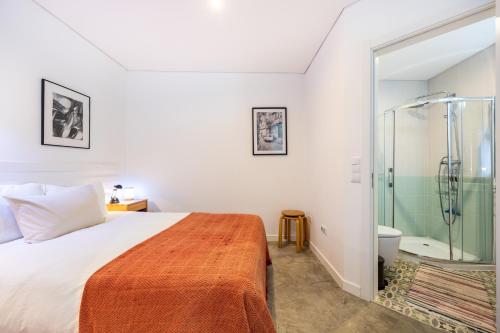 a bedroom with a bed and a shower at Perdiz do Mar in Olhão