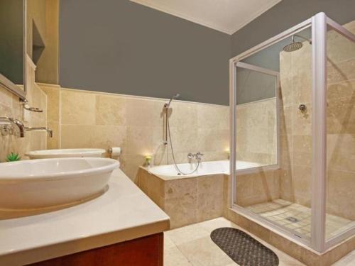 une salle de bain avec une douche, une baignoire et un lavabo dans l'établissement Villa de la Mer Hout Bay Beachfront, au Cap