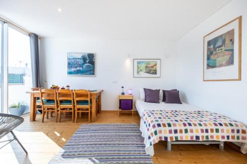 a bedroom with a bed and a dining table at Perdiz do Mar in Olhão