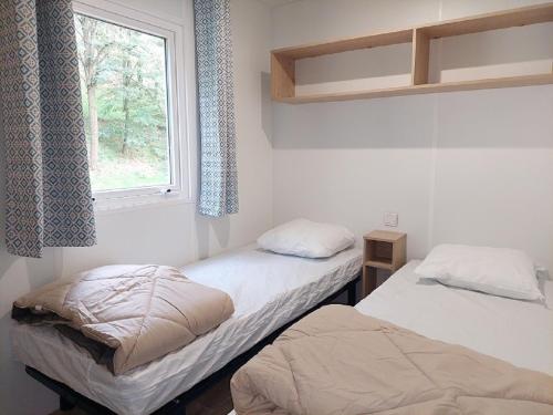 2 camas en una habitación con ventana en Camping de Retourtour, en Lamastre