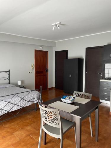 1 dormitorio con 1 cama, mesa y sillas en Sea Monolocale, en Falerna