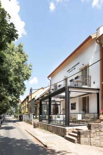 a building with a balcony on the side of a street at Lujza & Koriander in Vác