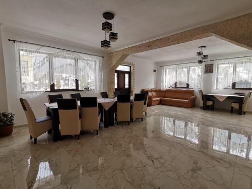 a dining room with a table and chairs and a couch at Casa Dana Olteanu in Moieciu de Sus