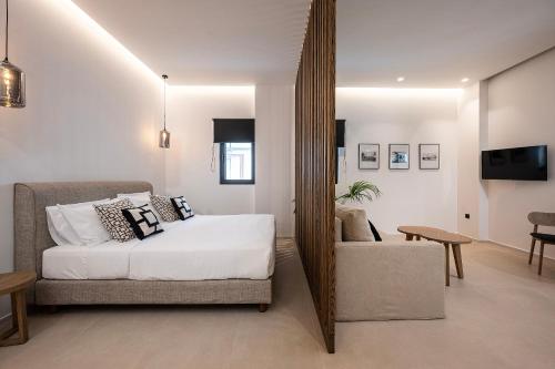 1 dormitorio con cama, silla y espejo en Apollon City Suites en Cos