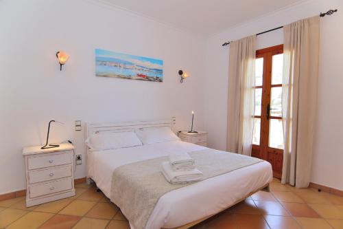 a bedroom with a white bed and a window at Villa Can Mussol 040 by Mallorca Charme in Sa Pobla