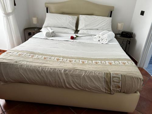 un letto con due asciugamani e una rosa sopra di Home Marty a Napoli