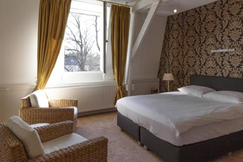 a bedroom with a bed and a window and a chair at Maison Au Parc in Maastricht