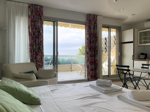 ein Schlafzimmer mit einem Bett und ein Wohnzimmer mit Aussicht in der Unterkunft Le Cap Vert 2Pers Vista Mare Piscina Parcheggio in Roquebrune-Cap-Martin