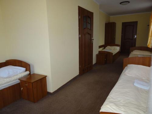 a room with two beds and two cabinets at Hostel Miłosz in Grabowiec