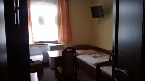 a small room with two beds and a window at Hostel Miłosz in Grabowiec