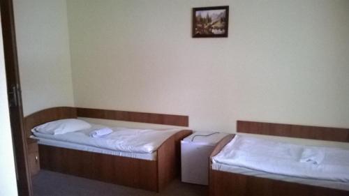 a room with two beds and a picture on the wall at Hostel Miłosz in Grabowiec