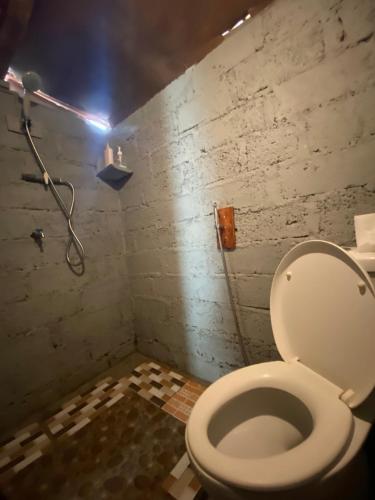 a bathroom with a white toilet in a room at D' Tepi Danau Glamping in Kintamani