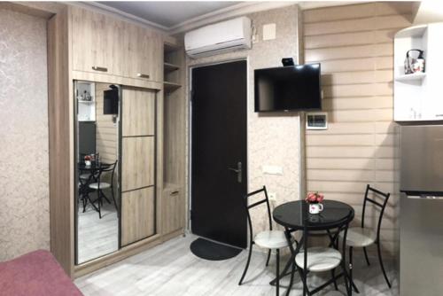 - une chambre avec une table, des chaises et une porte noire dans l'établissement Cozy Studio in the Center of Kutaisi, à Koutaïssi