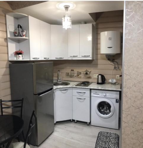 - une cuisine avec des placards blancs et un lave-linge dans l'établissement Cozy Studio in the Center of Kutaisi, à Koutaïssi
