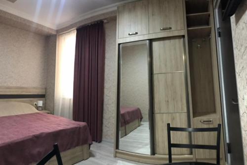 - une chambre d'hôtel avec un lit et un miroir dans l'établissement Cozy Studio in the Center of Kutaisi, à Koutaïssi