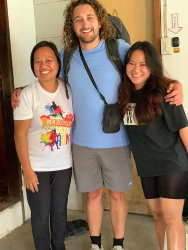 a man and two women posing for a picture at Paraiso Hostel Moalboal in Moalboal