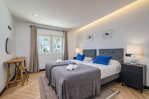 埃斯托利爾的住宿－Deluxe Monte Estoril，一间卧室配有两张带蓝色枕头的床