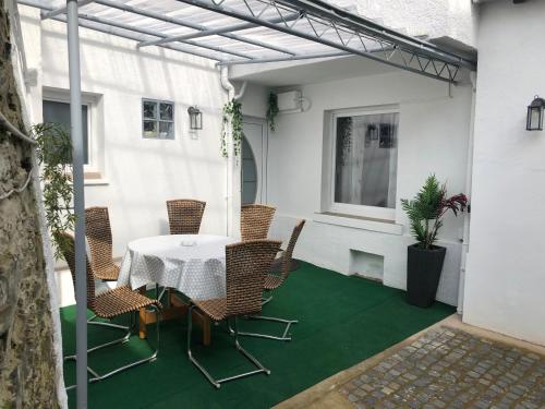 コッヘムにあるFerienhaus Herzblumeの緑の床にパティオ(テーブル、椅子付)
