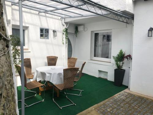 eine Terrasse mit einem Tisch und Stühlen auf einer grünen Etage in der Unterkunft Ferienhaus Herzblume in Cochem