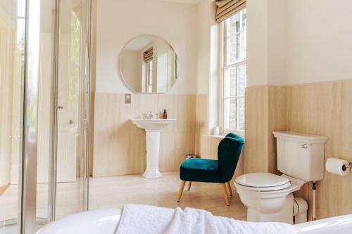 a bathroom with a toilet and a sink at Somerley House + Hut & Hot Tub in Lowestoft