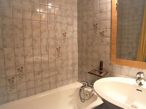 ein Badezimmer mit einer weißen Badewanne und einem Waschbecken in der Unterkunft Appartement Auris, 1 pièce, 6 personnes - FR-1-297-277 in Auris