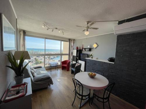 un salon avec un canapé et une table avec des chaises dans l'établissement Bel appartement T2 cabine avec parking, clim, proche plage et commerces, Saint-Cyprien - FR-1-106-71, à Saint-Cyprien