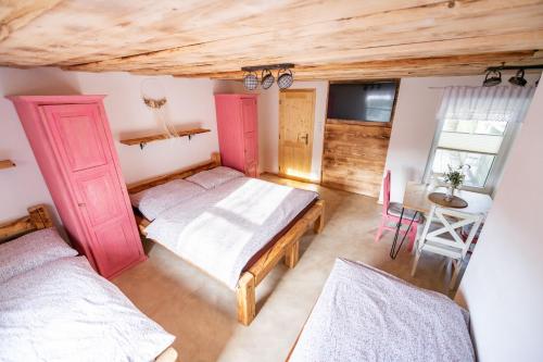 a bedroom with two beds and a table and a chair at Penzion - Vinařství Hanuš in Blučina