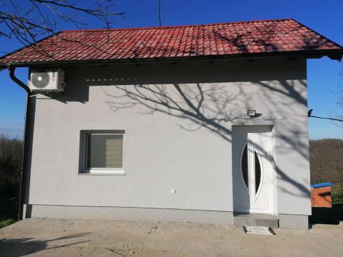 een wit huis met een raam en een rood dak bij Kuća za odmor Kustura in Ilok