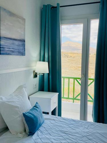 a bedroom with a bed with a view of the desert at Relaxing upper floor Apartment- exclusive complex. in Los Pocillos