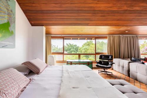 a living room with a large bed and a couch at Suítes encantadoras in Sao Paulo