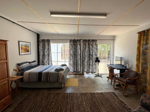 um quarto com uma cama, uma secretária e uma janela em Firefly Budget Friendly Guest House em Kempton Park