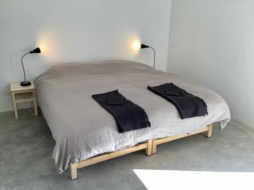a bed with two black shirts on top of it at Home Farm - theundergroundstream in Churchstow