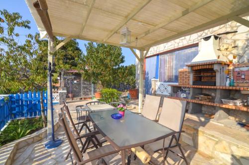 a patio with a table and chairs and a grill at Club Villamar - Apartment Amity in Maçanet de la Selva
