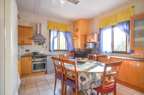 a kitchen with a table and chairs and a kitchen with yellow curtains at Club Villamar - Apartment Amity in Maçanet de la Selva