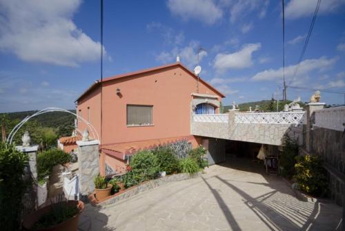 a pink house with a balcony and a building at Club Villamar - Apartment Amity in Maçanet de la Selva