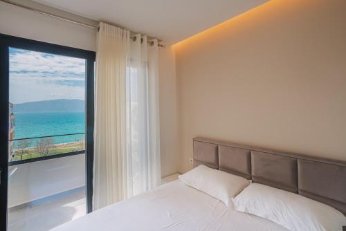a bedroom with a bed and a view of the ocean at JD Luxury Apartments in Vlorë