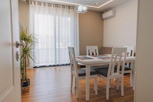 a dining room with a white table and chairs at JD Luxury Apartments in Vlorë