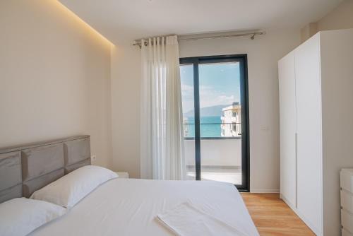 een slaapkamer met een bed en uitzicht op de oceaan bij JD Luxury Apartments in Vlorë