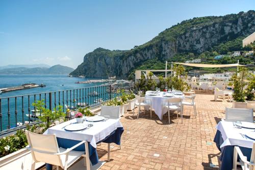 - un restaurant avec des tables et des chaises donnant sur l'océan dans l'établissement Relais Maresca Luxury Small Hotel & Terrace Restaurant, à Capri