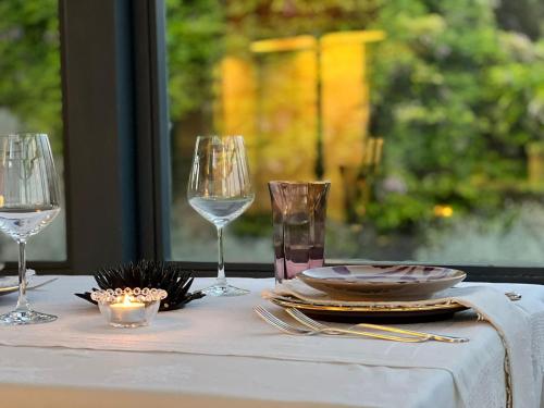 a table with two wine glasses and a plate on it at Masseria Spartivento in Conca Specchiulla