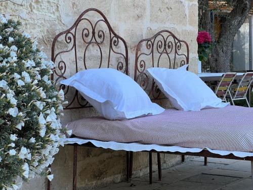 a bed with two pillows on it with flowers at Masseria Spartivento in Conca Specchiulla