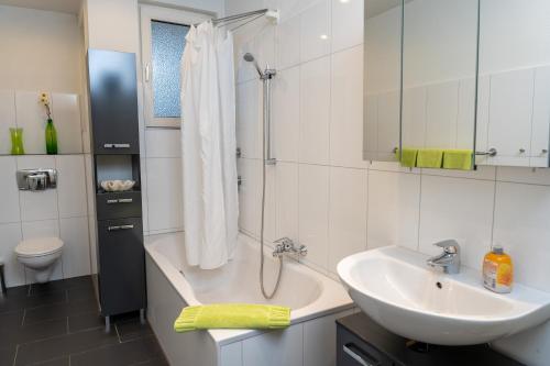 ein Bad mit einer Badewanne, einem Waschbecken und einer Dusche in der Unterkunft Art City Studio Kassel 6/9 in Kassel