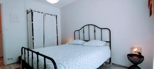 Schlafzimmer mit einem Bett mit einem schmiedeeisernen Kopfteil in der Unterkunft L'échappée belle PARKING Netflix Disney CLIM by Rentabao in Avignon