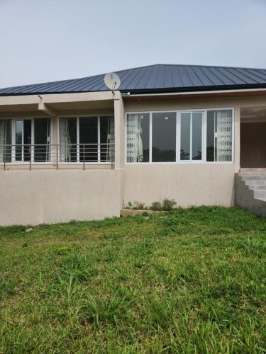 una casa con techo solar y patio en 3 Bedroom Serene home In Kwahu, 