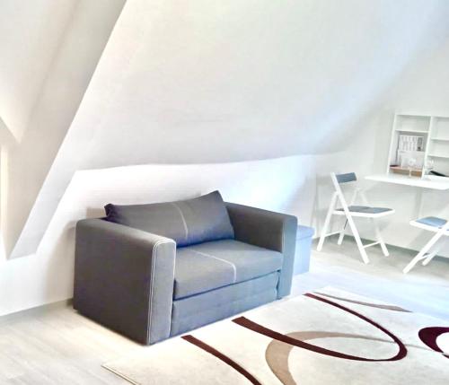 a living room with a blue chair and a rug at Tolle Wohnung in bester Lage von Heidenheim in Heidenheim