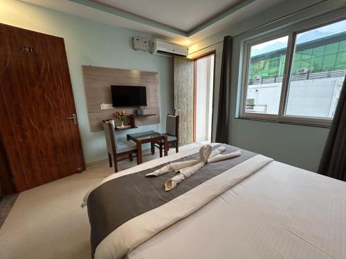 a bedroom with a large bed with a window at Hotel Kaanha Residency Inn By Shree Krishna Hospitality in Rishīkesh