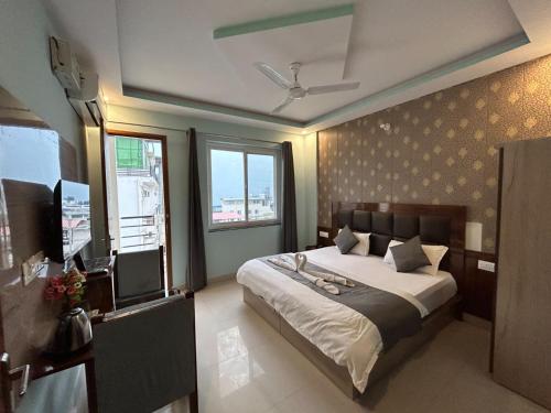 a bedroom with a large bed and a large window at Hotel Kaanha Residency Inn By Shree Krishna Hospitality in Rishīkesh