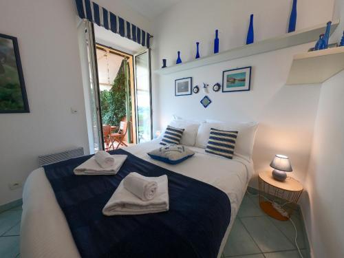 1 dormitorio con 1 cama con toallas en Le Marie Jeanne 6 Pers Giardino WiFi Vista Mare en Villefranche-sur-Mer