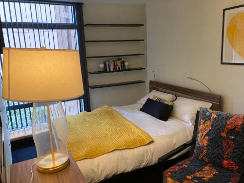 a bedroom with a bed and a lamp and a chair at Luxury Designer Apartment River view of Parliament Westminster Big Ben. in London