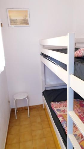 - une chambre avec 2 lits superposés et un tabouret dans l'établissement BAIE DES ANGES I Agréable 2 pièces cabine résidence avec piscine vue lagon Richelieu Cap d'Agde, au Cap d'Agde